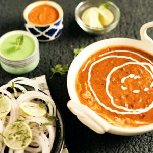 Close-up of homemade dal makhani served with lemon and onion garnish.